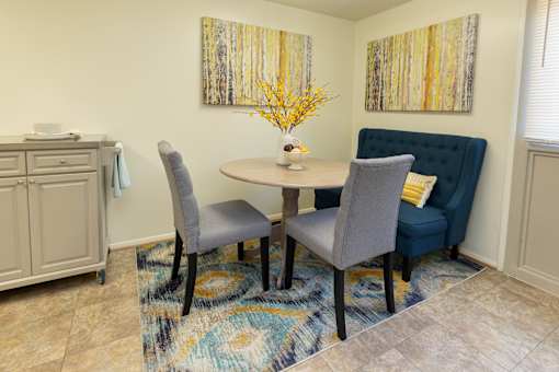 A dining room with a round table and grey chairs  at Winston Apartments, Baltimore, Maryland