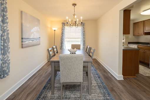 A dining room with a table and chairs.