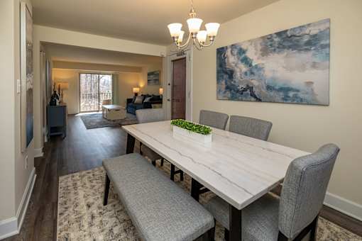 A dining room with a long table and grey chairs.