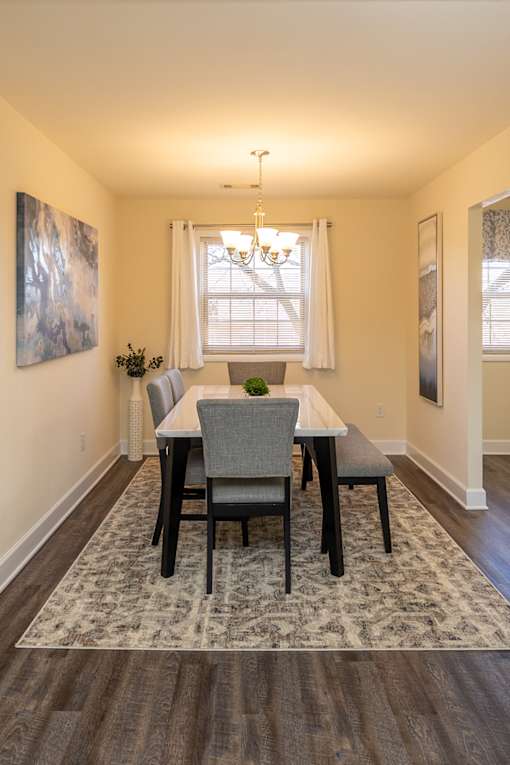 A dining room with a table and chairs.