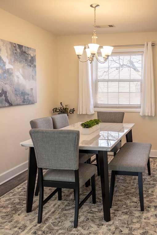 A dining room with a table and chairs.