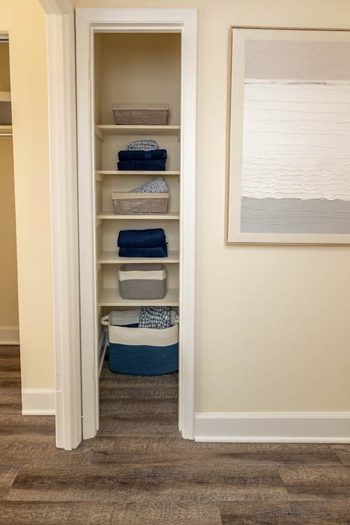 A linen closet with shelves and baskets.