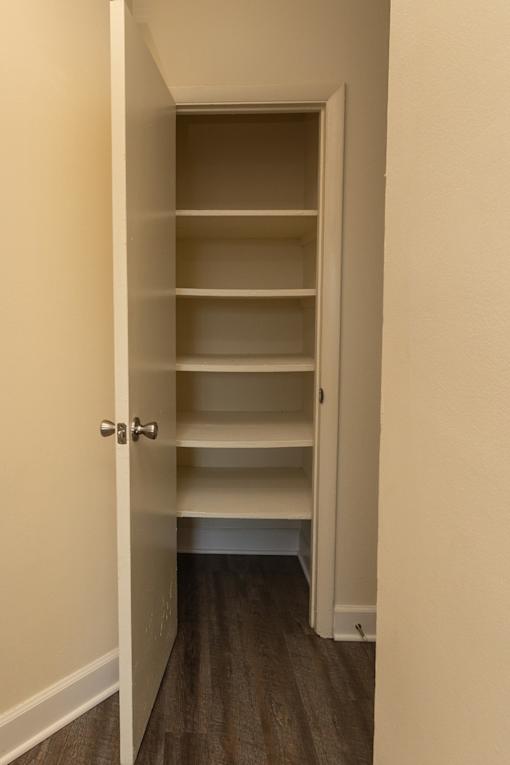 A white door with a handle is open to a hallway with shelves at Lawyers Hill Apartments, Elkridge, 21075