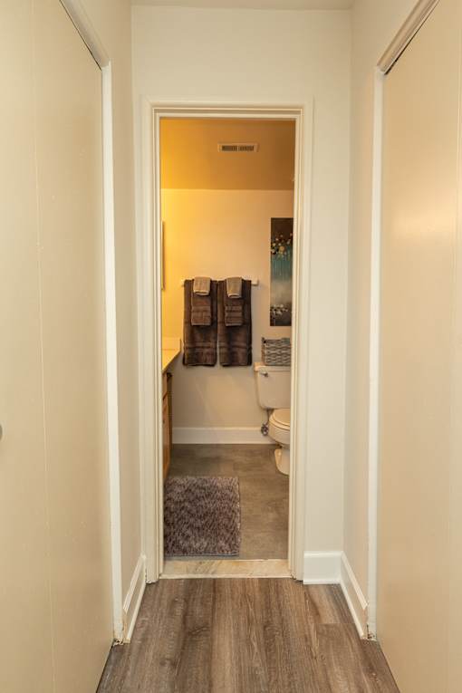 A bathroom with a toilet, sink, and towel rack.at Deer Park Apartments, Randallstown