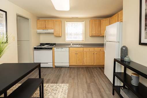 A kitchen with wooden cabinets and a black counter top.