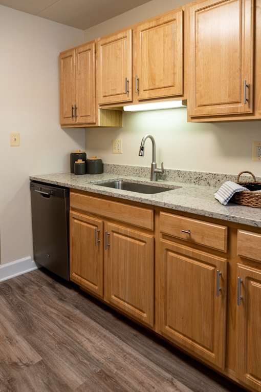 A kitchen with wooden cabinets and a granite countertop.