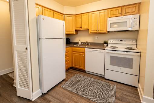 A kitchen with a white refrigerator and white stove.
