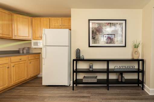 A kitchen with a white fridge and wooden cabinets.