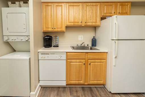 A kitchen with wooden cabinets and white appliances.at Deer Park Apartments, Randallstown, MD 21133