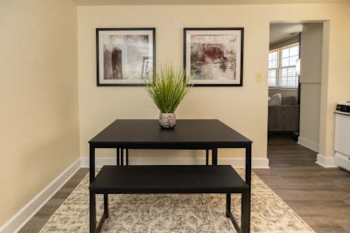 A black table with a plant on it and two framed pictures on the wall.