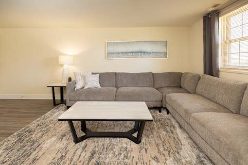 A living room with a grey couch and a coffee table.