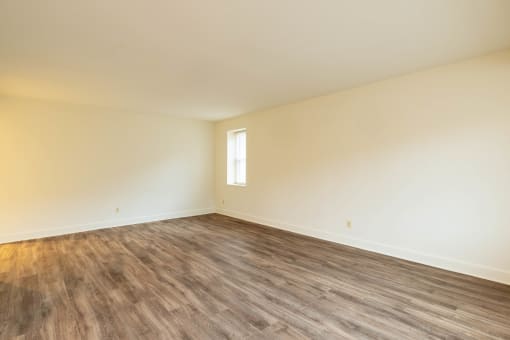 an empty room with white walls and a window  at Charlesgate Apartments, Maryland