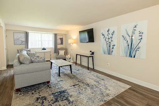 A living room with a couch, chair, and a rug.at Deer Park Apartments, Randallstown, MD