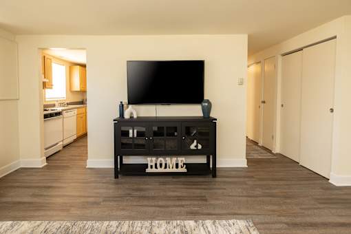 A black TV stand with the word HOME on it sits in a living room.