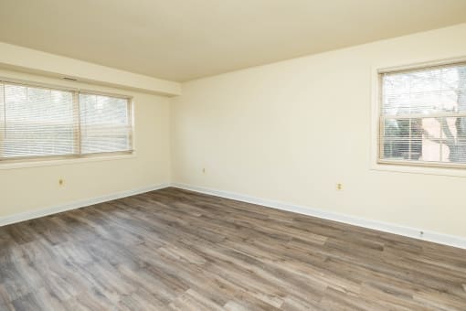 a bedroom with hardwood flooring and two windows at Seminary Roundtop Apartments, Lutherville, MD, 21093