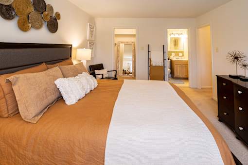 A bedroom with a large bed and a mirror on the wall.
