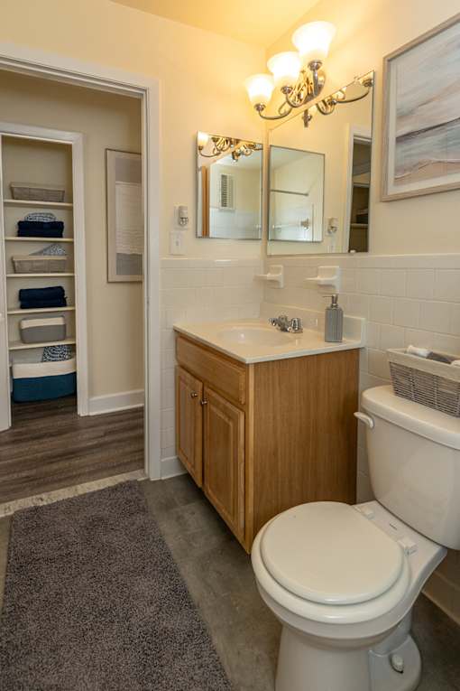 A bathroom with a toilet, sink, and a chandelier.