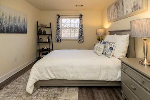 A bedroom with a white bed and a grey headboard.
