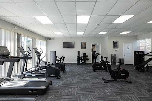 A spacious gym with treadmills, exercise bikes, and other equipment.