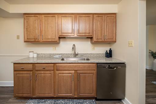 A kitchen with wooden cabinets and a granite countertop.