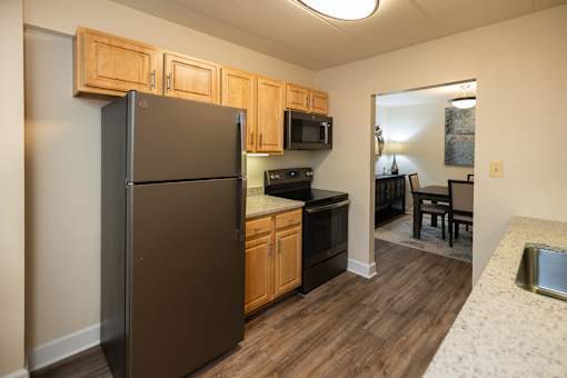 A kitchen with wooden cabinets and a granite countertop  at Ivy Hall Apartments*, Maryland, 21204