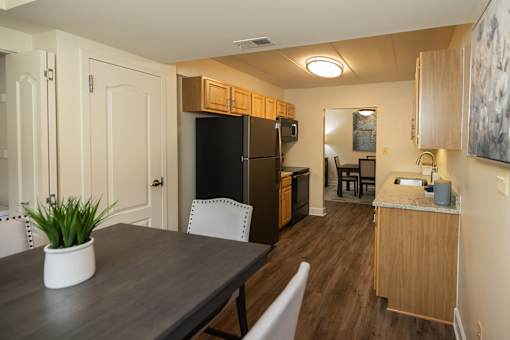 An eat-in kitchen with wooden cabinets and a granite countertop  at Ivy Hall Apartments*, Maryland, 21204