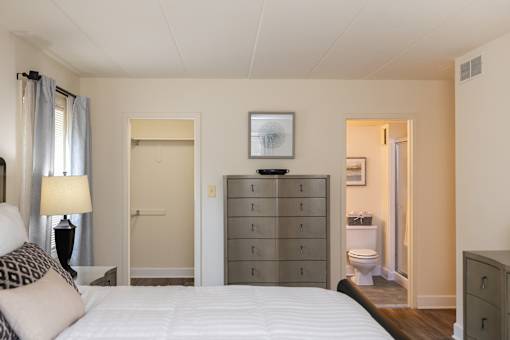 Bedroom with a bed looking into walk-in closet and ensuite bathroom at Ivy Hall Apartments*, Towson, MD 21204.