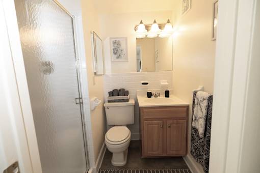 A bathroom with a toilet, sink, and mirror.