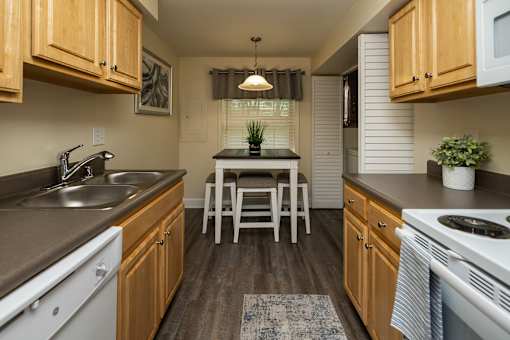 Eat-in kitchen with wooden cabinets and a dishwasher at Spring Hill Apartments & Townhomes, Baltimore, MD 21234.