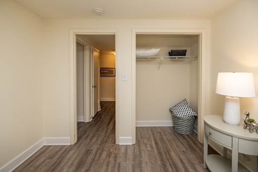 A room with a desk and a closet. Spring Hill Apartments & Townhomes, Baltimore, MD 21234