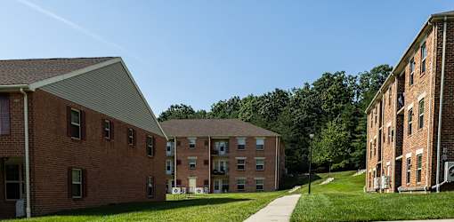 Exterior photo of landscaping and apartment buildings in Spring Hill Apartments & Townhomes, Baltimore, MD 21234.