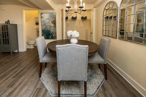 A dining room with a table and chairs.