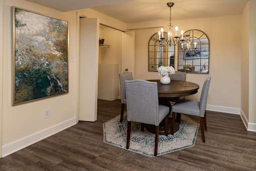 A dining room with a round table and chairs. Spring Hill Apartments & Townhomes, Baltimore, MD 21234