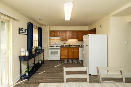 A kitchen with a white refrigerator and wooden cabinets.