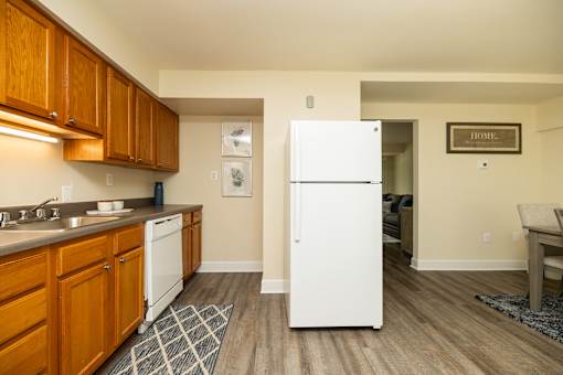 A kitchen with a white fridge and wooden cabinets.