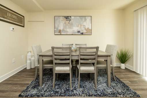 A dining room with a table and chairs.