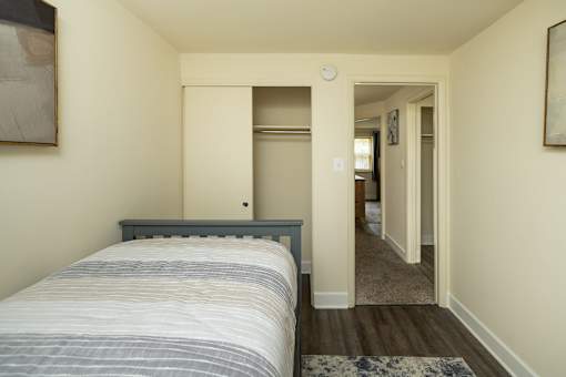 A bedroom with a bed and a doorway leading to another room.