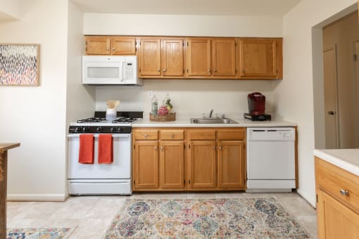 a kitchen with white appliances and wooden cabinets at Lawyers Hill Apartments, Elkridge, 21075