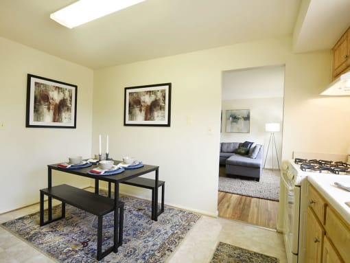 a living room with a dining table and a kitchen with a couch at Arbuta Arms Apartments*, Maryland