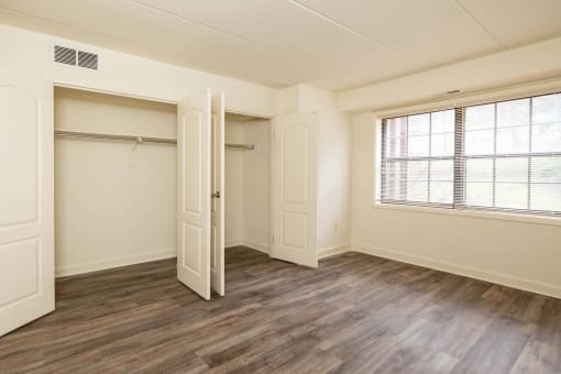 Bedroom with a large window and a closet at Ivy Hall Apartments*, Maryland, 21204