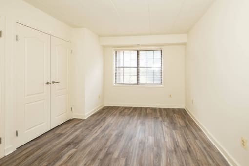 Bedroom with hardwood floors and white walls at Ivy Hall Apartments*, Maryland, 21204