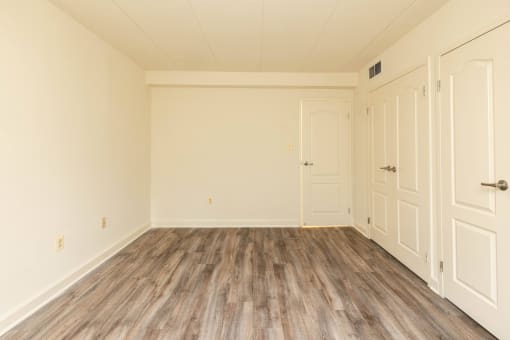 Bedroom with hardwood floors and white walls at Ivy Hall Apartments*, Maryland