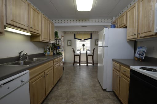 Kitchen with wooden cabinets and a white refrigerator at Ivy Hall Apartments*, Towson