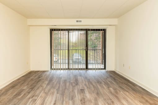 Empty room with a large window and wood floors at Ivy Hall Apartments*, Towson, 21204