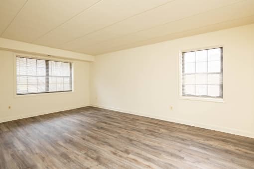 Bedroom with hardwood floors and two windows at Ivy Hall Apartments*, Towson, MD