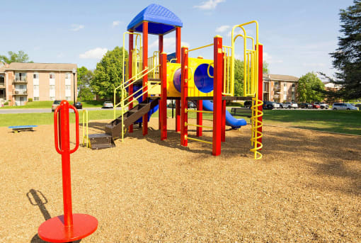 Colorful playground in a park with apartment buildings in the background at Fairbrook Park, Baltimore, 21244