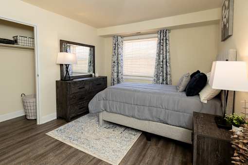 A second bedroom with a bed, nightstand, and a rug.