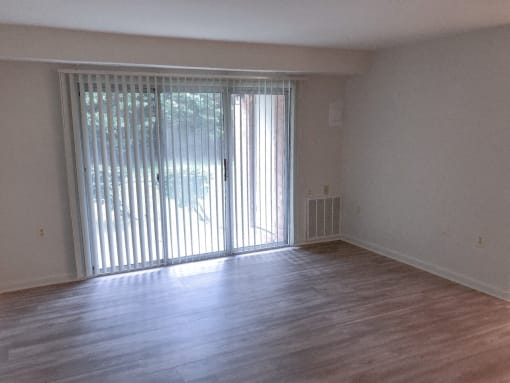 an empty living room with a sliding glass door at Seminary Roundtop Apartments, Lutherville, 21093