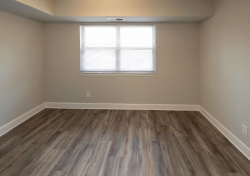 Empty room with hardwood floors and a window at McDonogh Village Apartments & Townhomes, Randallstown, Maryland