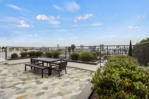 a patio with a table and chairs on a balcony with a view of the city